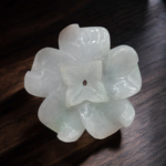Natural jadeite jade carved flower gemstone weighing 109.19 carats with faint green to white color, translucent finish, laboratory certified