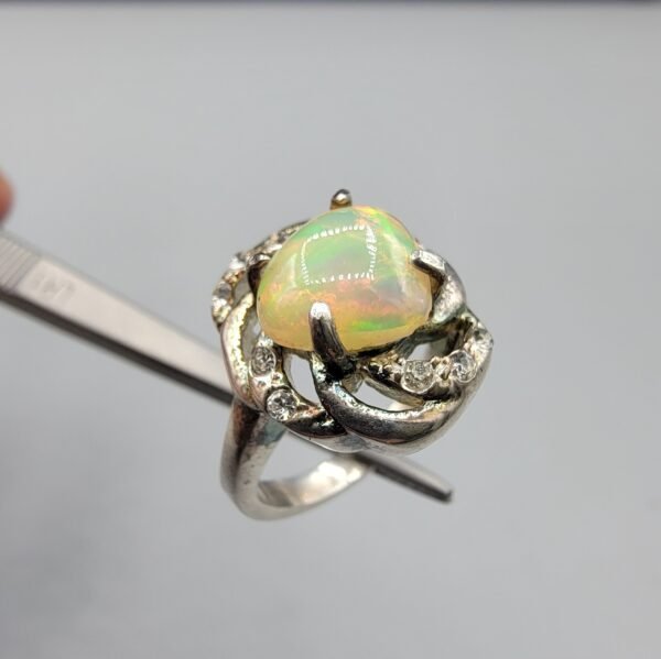 Natural Ethiopian Opal ring set in Turkish material steel, featuring a vibrant multicolor fire opal with decorative stones on a detailed metal design.