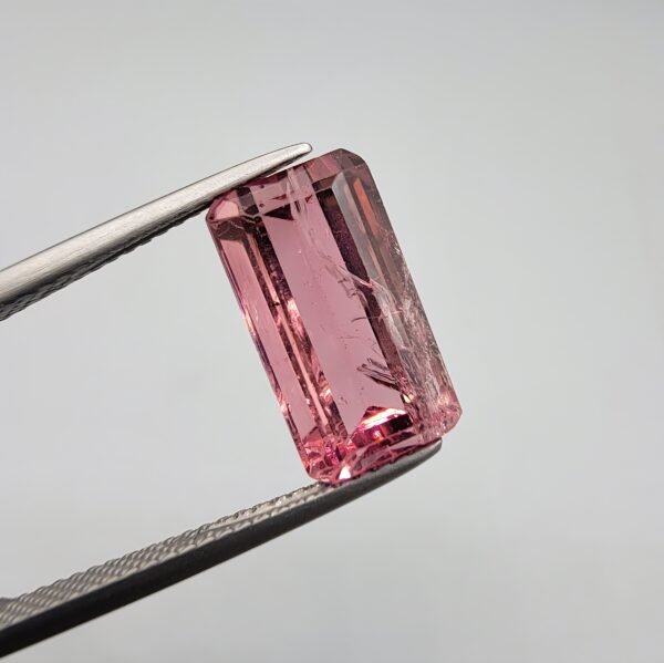 Natural pink tourmaline gemstone, 5.56 carat, emerald cut, Mozambique origin, vibrant rosy color.