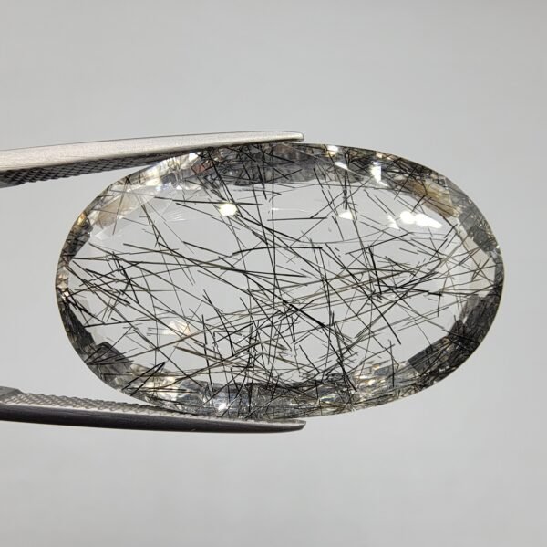 Natural rutilated quartz (Moh-E-Najaf) gemstone, 34 carat weight, oval cut, Iraq origin (Najaf), clear with black rutile inclusions.