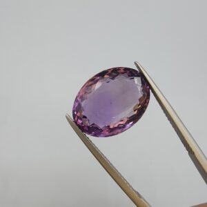 Natural Amethyst Katela gemstone oval cut, 9.85 carat weight, light purple color, transparent Brazilian amethyst held with tweezers.