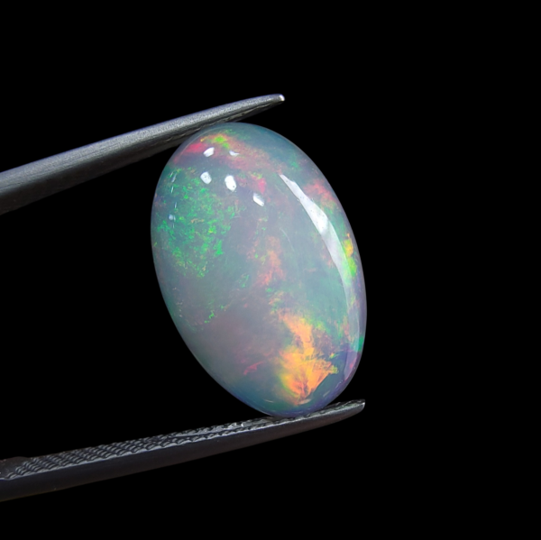 High-grade 3.37 carat natural Ethiopian Welo opal gemstone, featuring a vibrant multi-color "play-of-color" with neon green, orange, and red flashes.