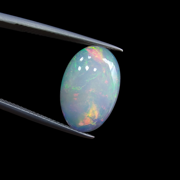 High-grade 3.37 carat natural Ethiopian Welo opal gemstone, featuring a vibrant multi-color "play-of-color" with neon green, orange, and red flashes.