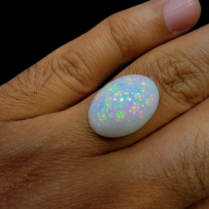 Rare 9 carat natural white Ethiopian opal featuring a distinct star-like "pinfire" play-of-color and high-dome oval cabochon cut.