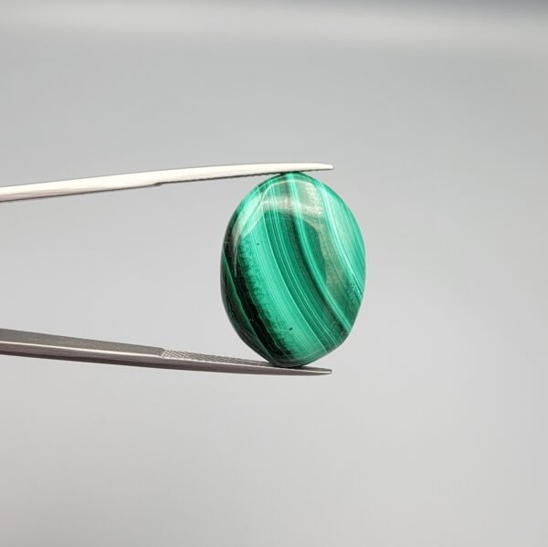 Large, high-polished 26.79 carat natural malachite (Dana-e-Farhang) gemstone featuring distinct forest green and emerald green banding in a smooth oval cabochon cut.