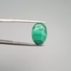 High-polished 8.02 carat natural malachite (Dana-e-Farhang) gemstone featuring fine, horizontal emerald green banding in a smooth oval cabochon cut.