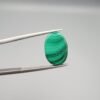 High-polished 8.02 carat natural malachite (Dana-e-Farhang) gemstone featuring fine, horizontal emerald green banding in a smooth oval cabochon cut.