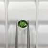 GGI certified 0.82 carat natural green tourmaline featuring an oval brilliant cut with exceptional transparency and vivid forest green color.
