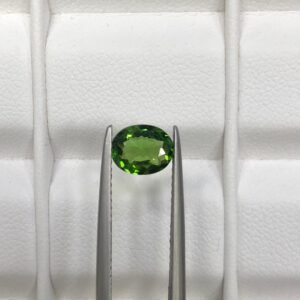 GGI certified 0.82 carat natural green tourmaline featuring an oval brilliant cut with exceptional transparency and vivid forest green color.