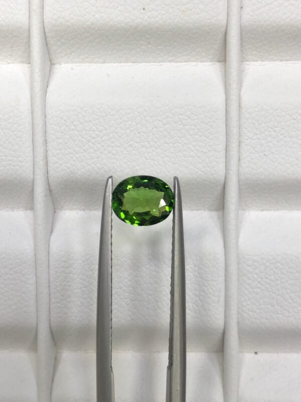 GGI certified 0.82 carat natural green tourmaline featuring an oval brilliant cut with exceptional transparency and vivid forest green color.