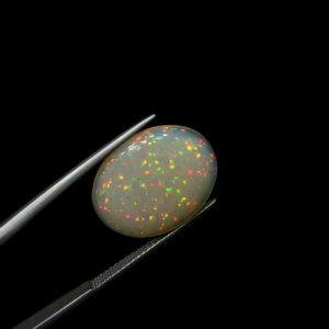 Rare 6.73 carat natural white Ethiopian star opal gemstone, showcasing a distinct six-rayed asterism effect and vibrant pinfire play-of-color in a high-dome oval cabochon.