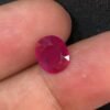 GGI certified 2.43 carat natural Mozambique ruby with a purplish red color, oval mixed cut, and transparent clarity, shown alongside its official gemstone report.
