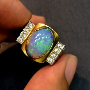 A custom-made sterling silver ring featuring a 4.70ct natural Australian opal cabochon with intense green and blue fire, accented by round diamonds on a wide, sturdy dual-tone band.