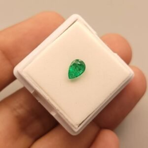 Vibrant 0.70 carat natural Swat emerald with a classic pear-shaped brilliant cut, showcasing the signature deep "Swat green" color and characteristic inclusions, presented in a gemstone box.