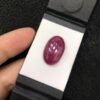 GGI certified 22.41 carat natural star ruby featuring a translucent red body and a smooth oval cabochon cut.