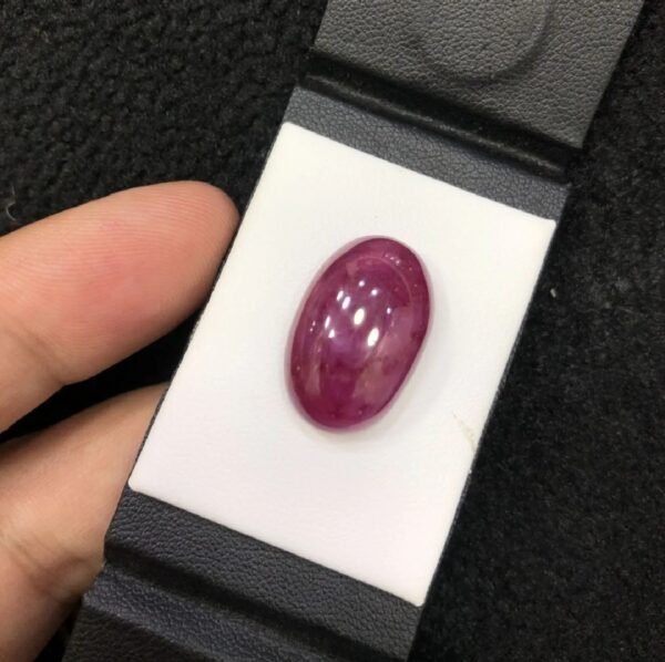 GGI certified 22.41 carat natural star ruby featuring a translucent red body and a smooth oval cabochon cut.