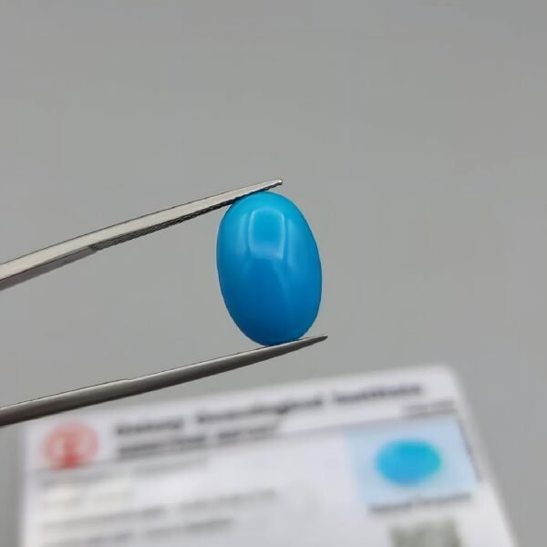 GGI certified 9.03 carat natural Arizona turquoise (Feroza) featuring a vibrant sky-blue color and a perfectly polished oval cabochon cut.