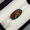 High-luster 3.50 carat natural Egyptian turquoise (Feroza) oval cabochon with a bright teal-blue body and a distinct, scattered dark brown matrix.