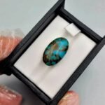 Significant 15.29 carat natural Egyptian turquoise (Feroza) oval cabochon with a rich teal-blue body and an extensive, earthy brown spiderweb matrix.