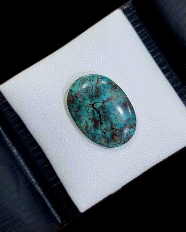 High-polished 4.18 carat natural Egyptian turquoise (Feroza) featuring a classic teal-blue body with a dense, intricate dark brown spiderweb matrix in an oval cabochon cut.