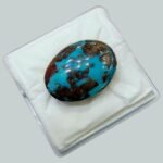 Massive 34.93 carat natural Egyptian turquoise (Feroza) oval cabochon featuring a vibrant teal-blue body with an extensive, high-contrast dark brown spiderweb matrix.
