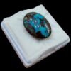 Massive 34.93 carat natural Egyptian turquoise (Feroza) oval cabochon featuring a vibrant teal-blue body with an extensive, high-contrast dark brown spiderweb matrix.