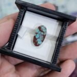 High-contrast 4.09 carat natural Egyptian turquoise (Feroza) oval cabochon featuring sky-blue "islands" within a rich, reddish-brown iron stone matrix.