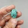 Large 19.65 carat natural Egyptian turquoise (Feroza) oval cabochon featuring a bright robin's egg blue body with a fine, scattered dark black-brown speckled matrix.