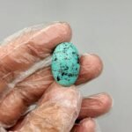 Large 19.65 carat natural Egyptian turquoise (Feroza) oval cabochon featuring a bright robin's egg blue body with a fine, scattered dark black-brown speckled matrix.