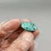 Large 19.65 carat natural Egyptian turquoise (Feroza) oval cabochon featuring a bright robin's egg blue body with a fine, scattered dark black-brown speckled matrix.