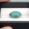 Premium 10.40 carat natural Egyptian turquoise (Feroza) oval cabochon displaying a vivid sky-blue body with an intricate, dark chocolate-brown spiderweb matrix, shown in a black jeweler's box.
