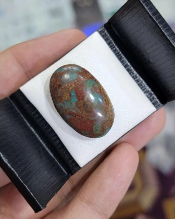 Oversized 24.63 carat natural Egyptian turquoise (Feroza) oval cabochon with a vivid teal-blue body and a dense, earthy reddish-brown iron stone matrix.