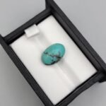 Vibrant 7.04 carat natural Egyptian turquoise (Feroza) oval cabochon displaying a luminous sky-blue surface with a delicate, fine dark-brown spiderweb matrix.