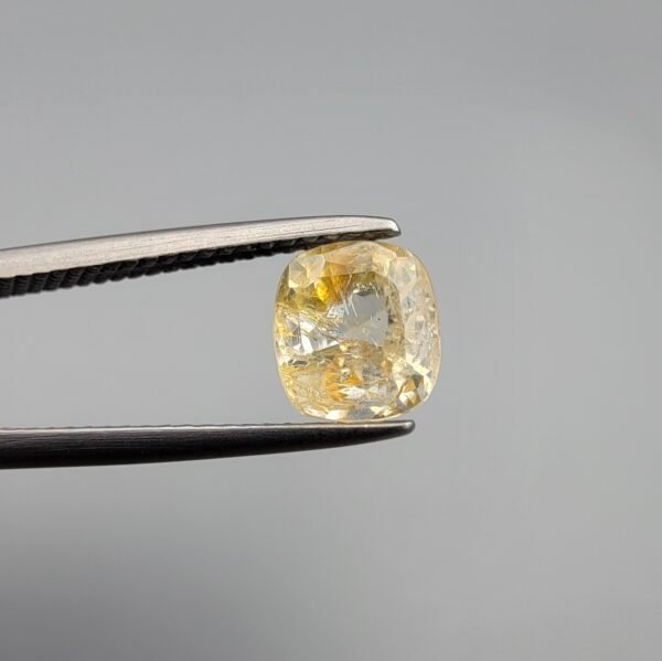 ​A 1.76 carat natural yellow sapphire (Pukhraj) from Sri Lanka, featuring a classic cushion cut and a clear, sun-bright yellow hue.
