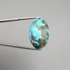 A massive 35.11-carat natural Iranian Turquoise (Feroza) from Kerman City, featuring a high-domed oval cabochon cut, saturated sky-blue color, and a brilliant golden pyrite matrix, shown from multiple angles.