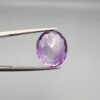 A 11.05-carat natural purple Amethyst (Katela) from Brazil, featuring a brilliant oval faceted cut with exceptional clarity and deep violet saturation, shown in jeweler's tweezers.