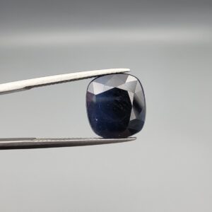 A 10.95-carat natural deep blue Sapphire from Afghanistan, featuring a professional oval facet cut, presented in a jeweler's display case.