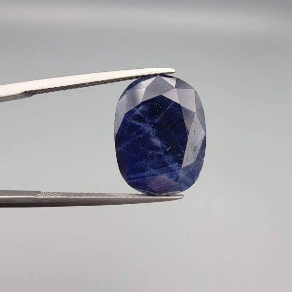 A 12.80-carat natural deep blue Sapphire from Afghanistan, featuring an elegant oval facet cut, displayed in a professional jeweler's gemstone box.