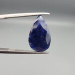 An 8.24-carat natural blue Sapphire from Afghanistan, featuring a professional pear-shaped facet cut, displayed in a gemstone box.