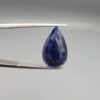 An 8.24-carat natural blue Sapphire from Afghanistan, featuring a professional pear-shaped facet cut, displayed in a gemstone box.