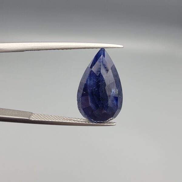 An 8.24-carat natural blue Sapphire from Afghanistan, featuring a professional pear-shaped facet cut, displayed in a gemstone box.