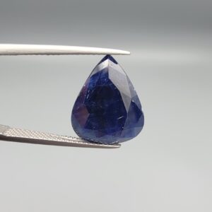 A 13.18-carat natural deep blue Sapphire from Afghanistan, master-faceted into a pear shape and displayed in a professional gemstone box.