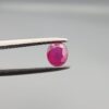 ​A 0.47-carat natural red Ruby (Yaqoot) from Kabul, Afghanistan, featuring an oval faceted cut with rich red color and natural inclusions, held in jeweler's tweezers.