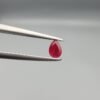 A 0.44-carat natural red Ruby (Yaqoot) from Kabul, Afghanistan, featuring a brilliant pear faceted cut with rich red color and natural organic inclusions, held in jeweler's tweezers.