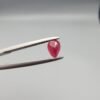 A 0.44-carat natural red Ruby (Yaqoot) from Kabul, Afghanistan, featuring a brilliant pear faceted cut with rich red color and natural organic inclusions, held in jeweler's tweezers.
