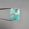​A 29.83-carat natural blue-green Turquoise (Feroza) from Kerman, Iran, featuring a unique rectangle cabochon cut with a shimmering golden pyrite matrix.