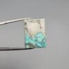 ​A 29.83-carat natural blue-green Turquoise (Feroza) from Kerman, Iran, featuring a unique rectangle cabochon cut with a shimmering golden pyrite matrix.