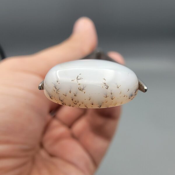 A premium 7.89-carat natural Iranian Milky Dendritic Agate (Shajari Dudhiya Aqeeq) with a high-translucency white body and sharp, tree-like dendritic patterns visible on both sides, held in jeweler's tweezers.