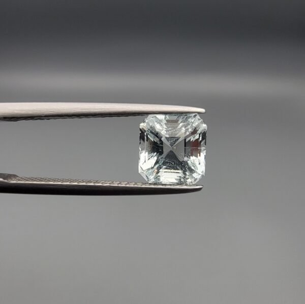 ​A 2.15-carat natural Shigar Valley Aquamarine (Beruj) gemstone with an octagon emerald cut, featuring clear sky-blue color and beautiful natural inclusions, held in jeweler's tweezers.