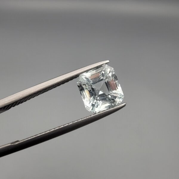 ​A 2.15-carat natural Shigar Valley Aquamarine (Beruj) gemstone with an octagon emerald cut, featuring clear sky-blue color and beautiful natural inclusions, held in jeweler's tweezers.
